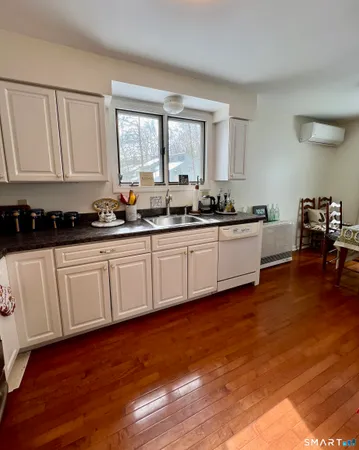 a kitchen with stainless steel appliances granite countertop a sink a stove cabinets and wooden floor