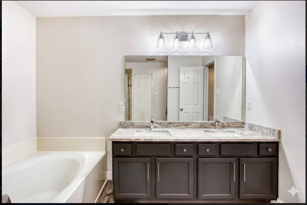 4020 Cherry Ridge Drive Frisco, TX 75033 - Photo 11 of 12 a bathroom with a sink vanity granite tub and a mirror