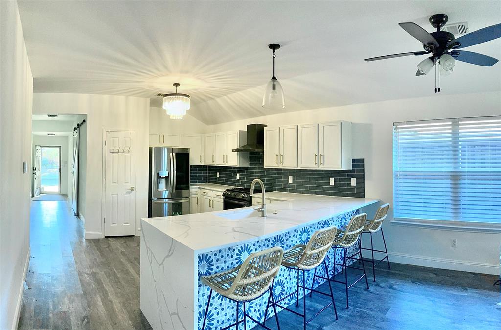 4020 Cherry Ridge Drive Frisco, TX 75033 - Photo 8 of 12 a kitchen with granite countertop a table chairs stainless steel appliances and wooden floor