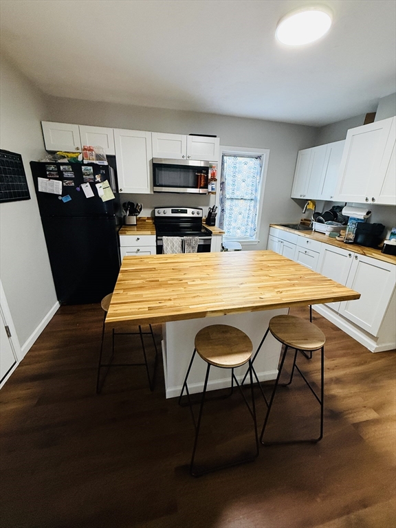 26 Edgeworth Street, Unit 1 Worcester, MA 01605 - Photo 4 of 13 a kitchen with a dining table chairs and refrigerator