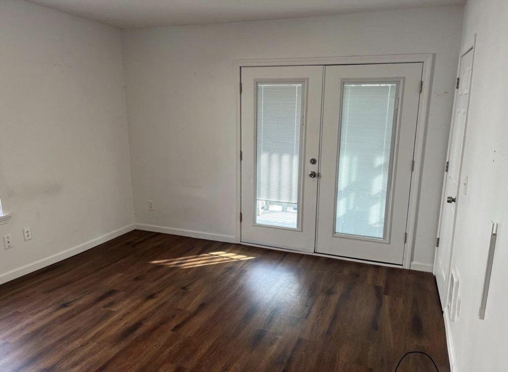 26 Edgeworth Street, Unit 1 Worcester, MA 01605 - Photo 10 of 13 an empty room with wooden floor and windows
