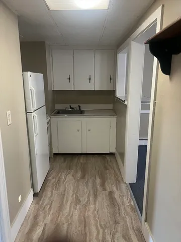 a kitchen with a refrigerator sink and cabinets