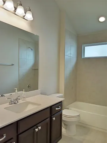 a bathroom with a granite countertop sink a toilet and a bathtub