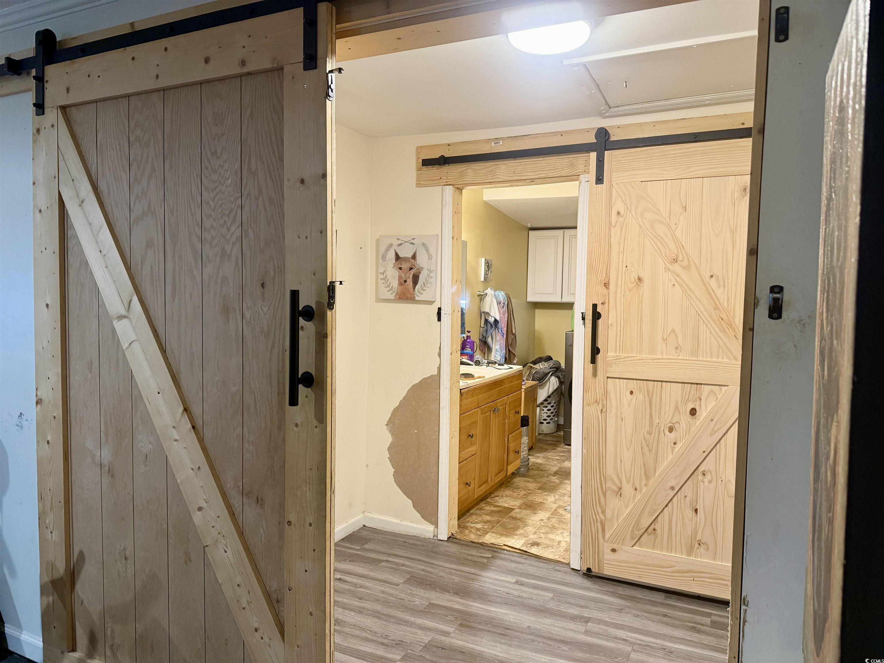 2408 South Island Road Georgetown, SC 29440 - Photo 23 of 35 Hallway with a barn door and light wood-style floo