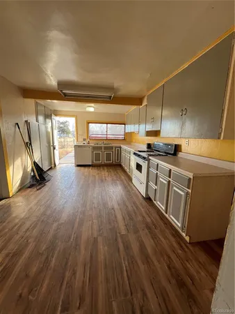 a large kitchen with a lot of counter space and a wooden floor