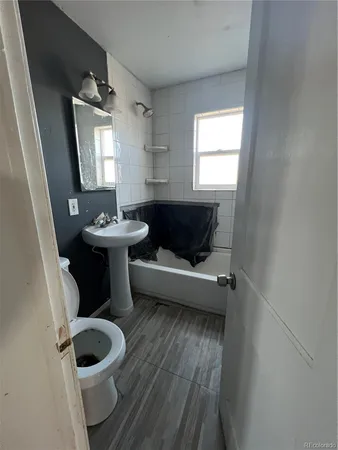 a bathroom with a toilet sink and mirror