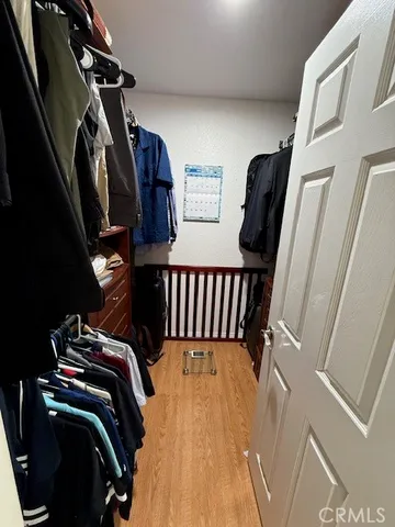 a view of walk in closet with clothes and shoes