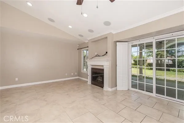 a view of an empty room with a fireplace and a window