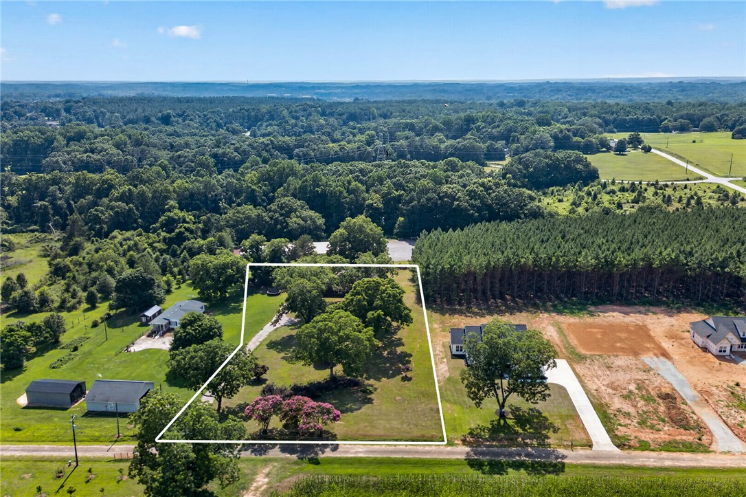 1412 Simpson Road Pendleton, SC 29670 - Photo 2 of 48 An aerial perspective showcases a generously sized property enveloped by verdant woodlands, offering secluded tranquility.
