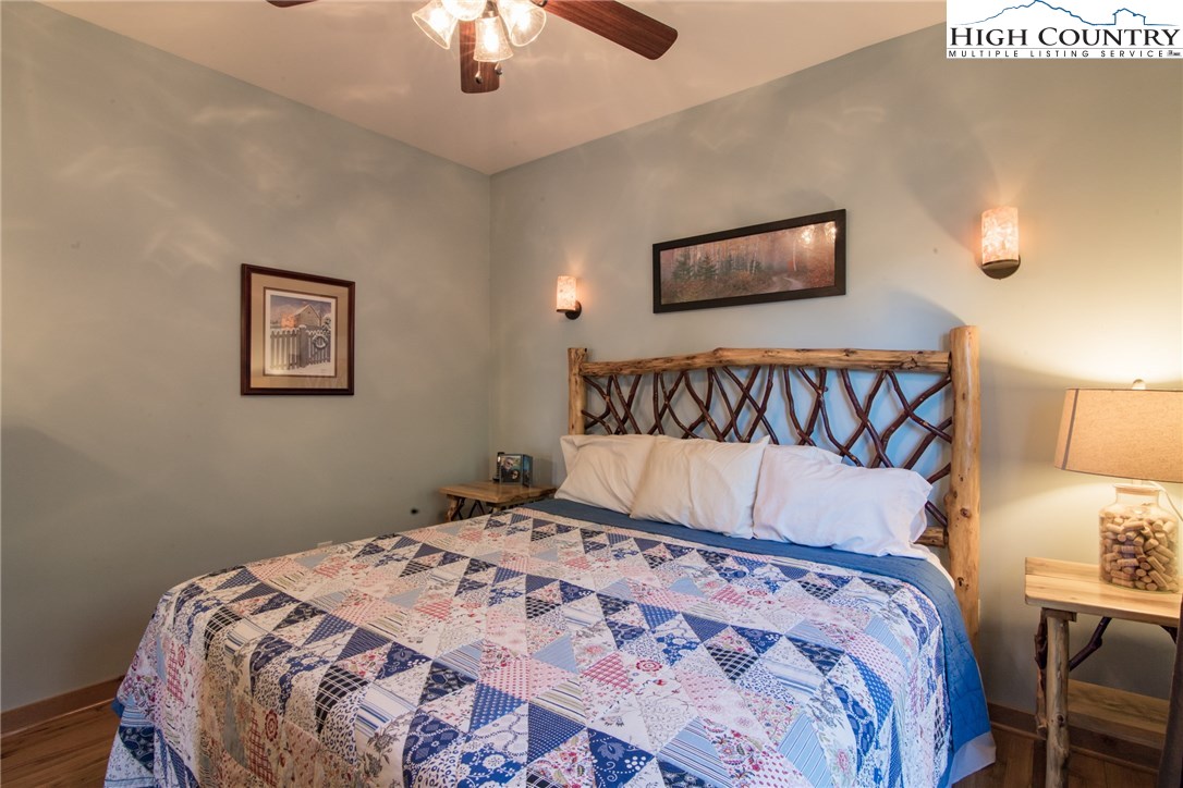 4091 Staghorn Road Purlear, NC 28665 - Photo 21 of 47 a bedroom with a large bed and a chandelier