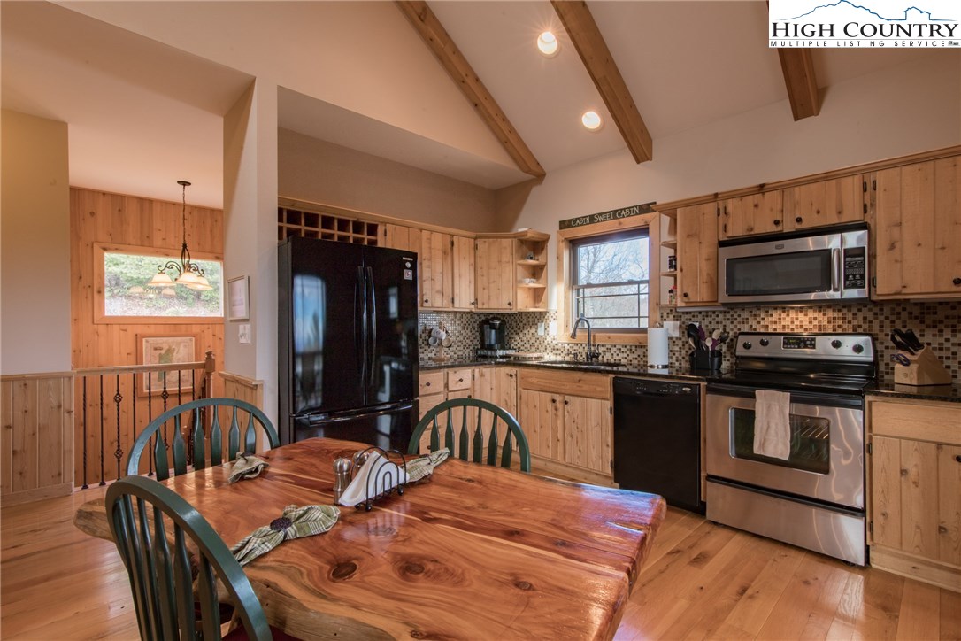 4091 Staghorn Road Purlear, NC 28665 - Photo 7 of 47 a kitchen with stainless steel appliances granite countertop a stove top oven a sink a dining table and chairs