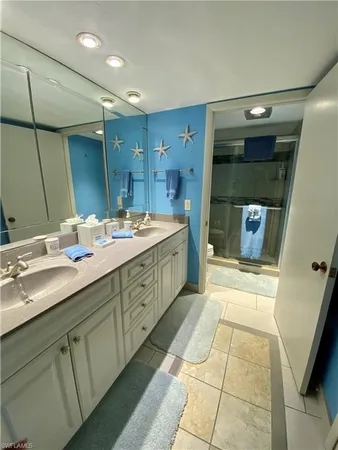 a spacious bathroom with a double vanity sink a mirror and a shower