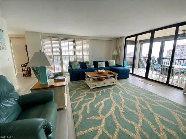 a living room with furniture and a floor to ceiling window