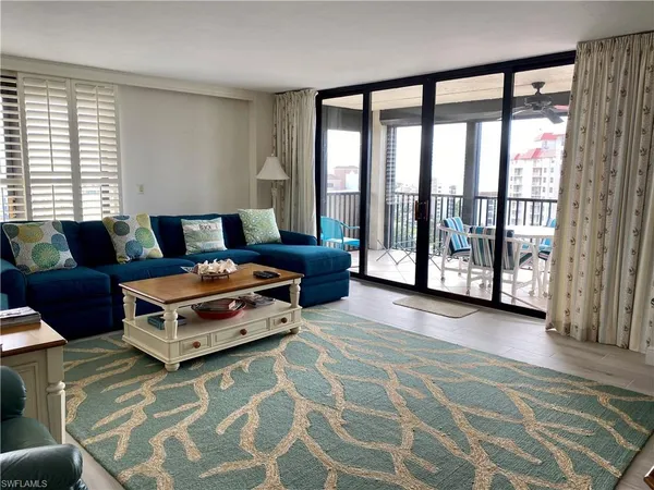 a living room with furniture and a floor to ceiling window