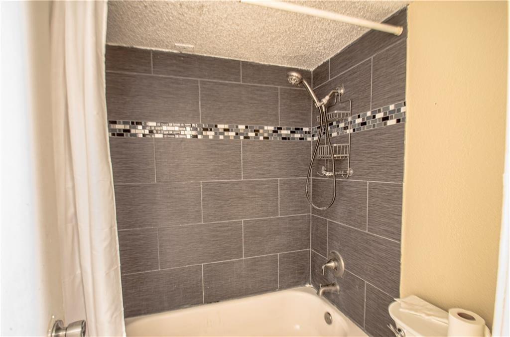 9835 Walnut Street, Unit 202 Dallas, TX 75243 - Photo 17 of 19 Shower-over-tub combination with large format gray tile surround