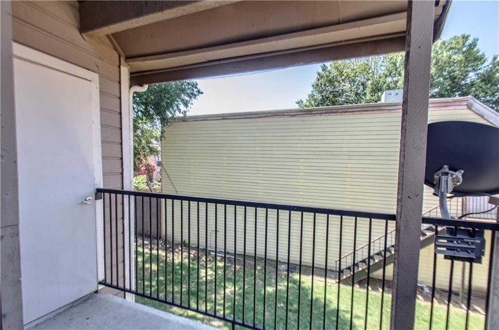 9835 Walnut Street, Unit 202 Dallas, TX 75243 - Photo 18 of 19 Private exterior balcony with concrete flooring, wood-paneled siding, and a black metal railing