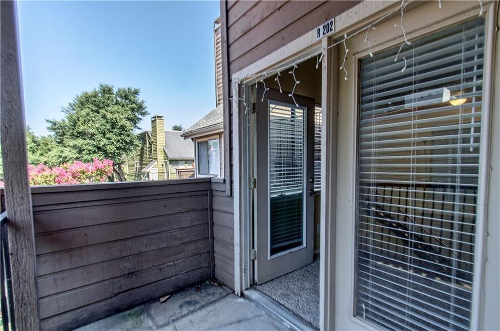 9835 Walnut Street, Unit 202 Dallas, TX 75243 - Photo 2 of 19 Private balcony featuring horizontal siding, a concrete floor, and direct access to interior spaces through a glass-paneled door and a large window