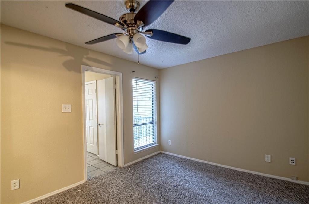 9835 Walnut Street, Unit 202 Dallas, TX 75243 - Photo 5 of 19 Bedroom with textured carpeting, neutral wall paint, and a ceiling fan with integrated lighting