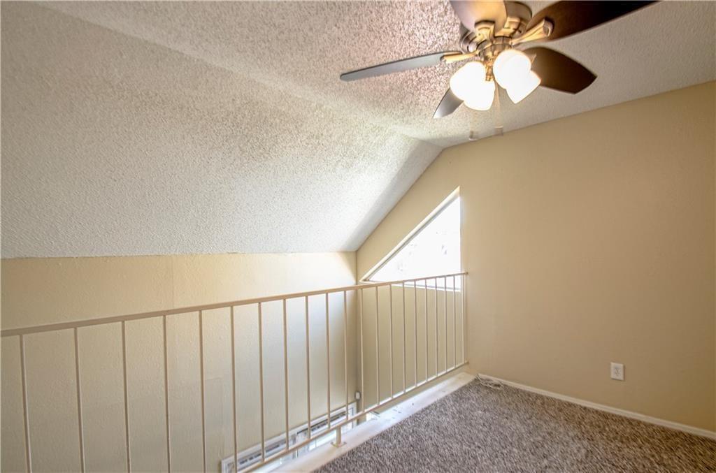9835 Walnut Street, Unit 202 Dallas, TX 75243 - Photo 8 of 19 Carpeted loft area featuring a sloped ceiling, ceiling fan with light kit, and a triangular window