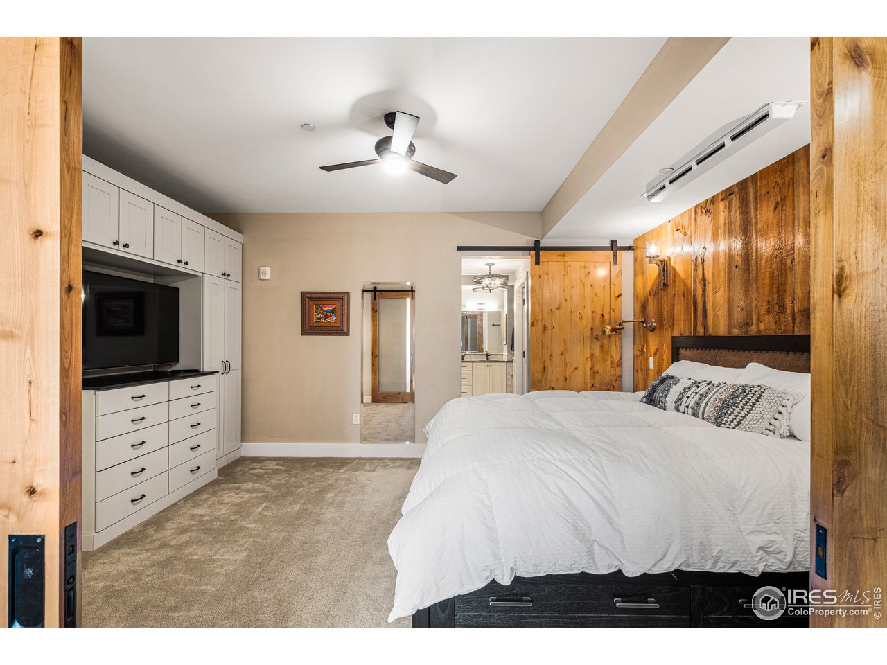 901 Pearl Street, Unit 202 Boulder, CO 80302 - Photo 18 of 35 a bedroom with a large bed and flat tv screen on dresser