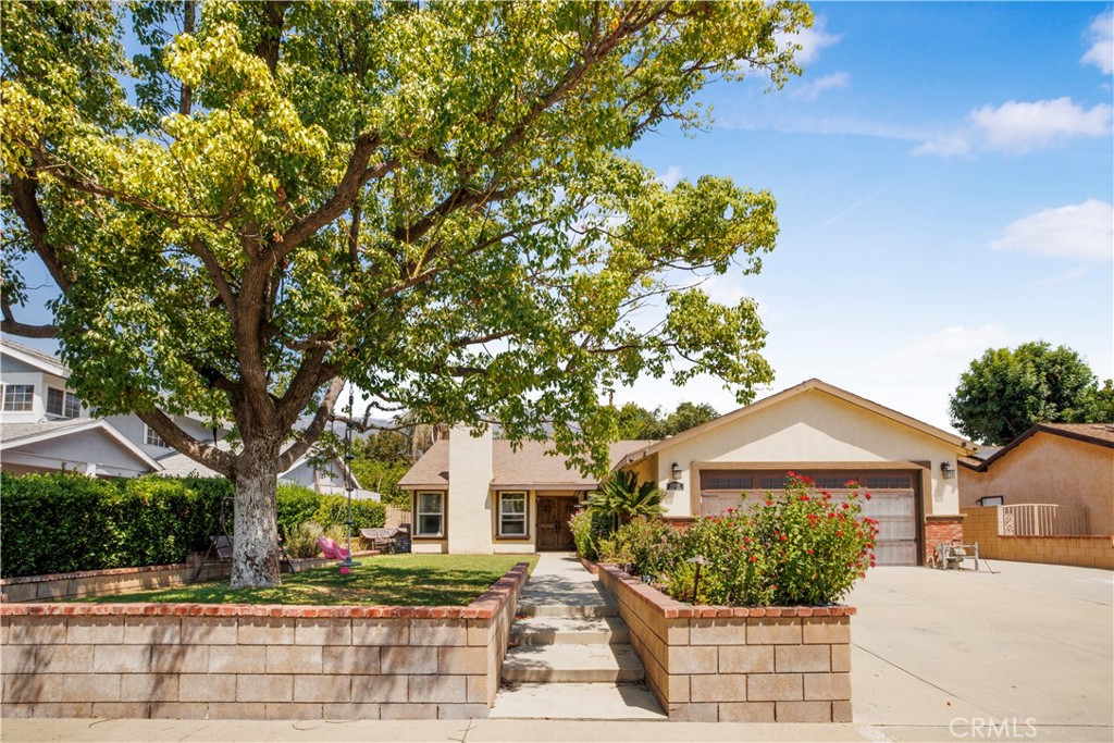 10330 Orange Street Rancho Cucamonga, CA 91737 - Photo 1 of 1 a front view of a house with a yard and potted plants