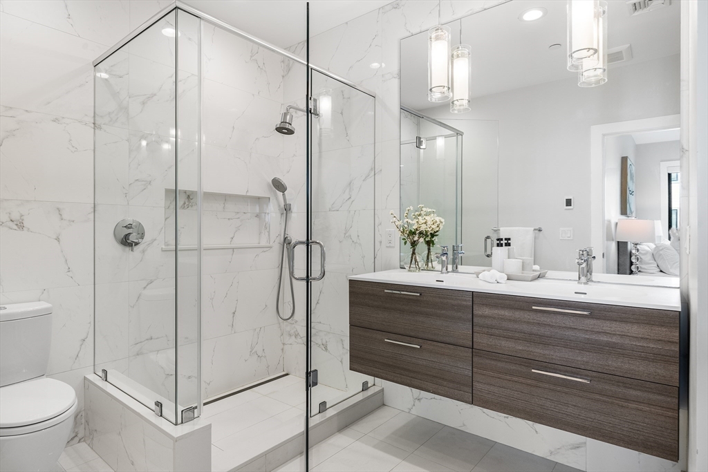 39 A Street, Unit 19 Boston, MA 02127 - Photo 13 of 24 a bathroom with a shower sink and toilet