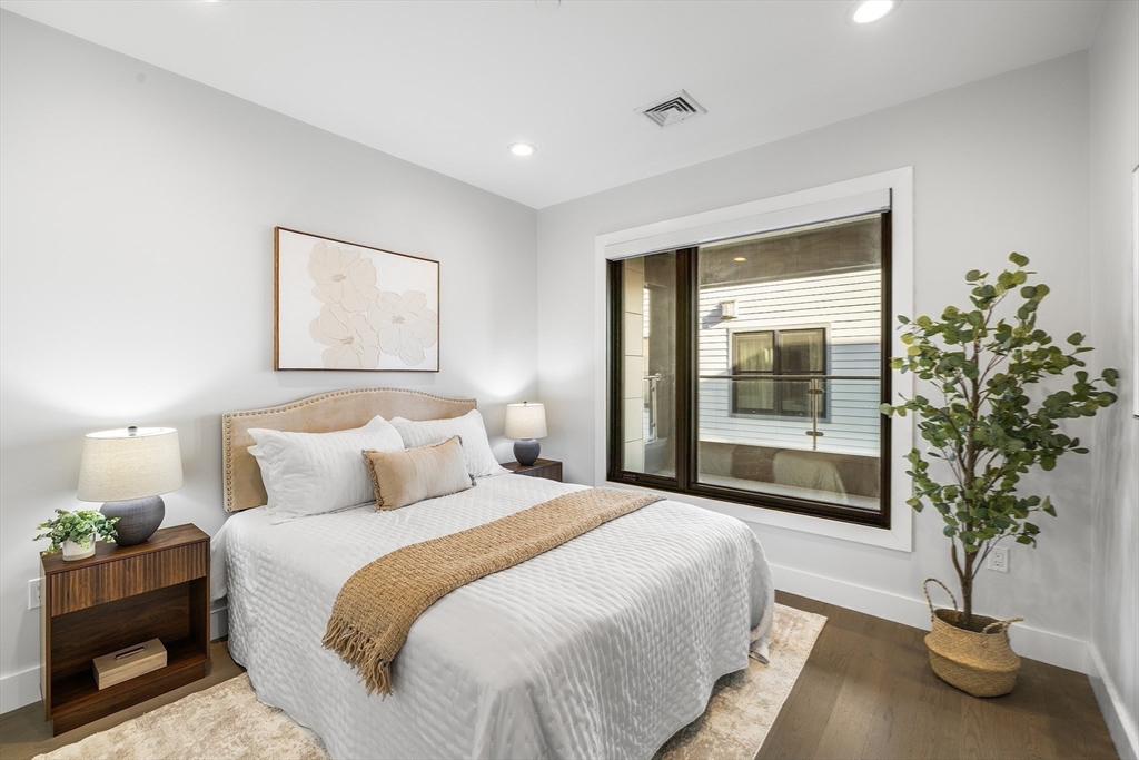 39 A Street, Unit 19 Boston, MA 02127 - Photo 18 of 24 a bedroom with a large bed and a potted plant