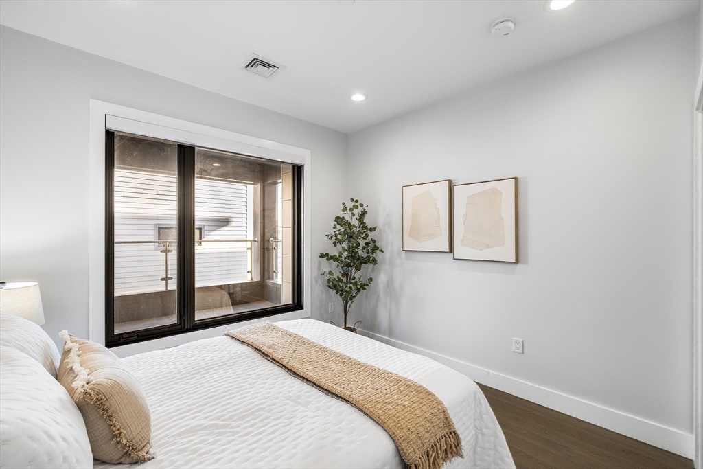 39 A Street, Unit 19 Boston, MA 02127 - Photo 19 of 24 a bedroom with a bed and a large mirror