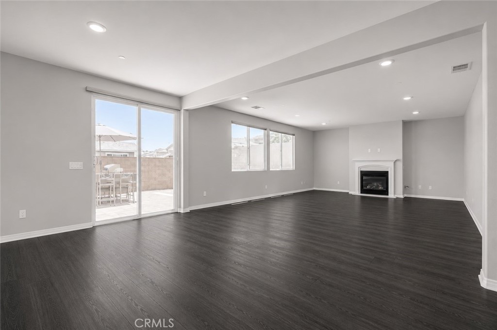 11056 Guffey Ranch Way Corona, CA 92883 - Photo 16 of 61 a view of an empty room with wooden floor and a window