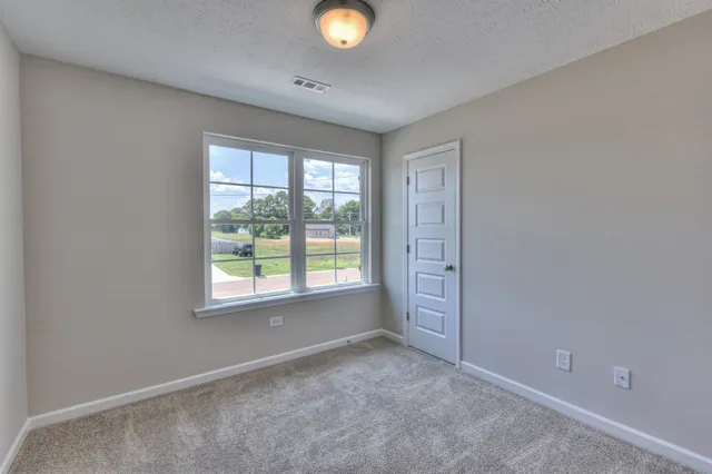 an empty room with windows and closet