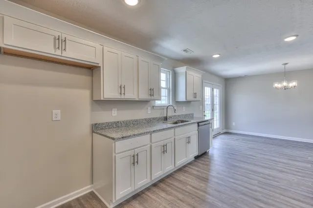 a kitchen with a sink cabinets and wooden floor
