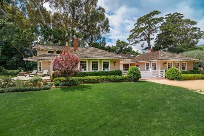 a front view of a house with a yard and trees