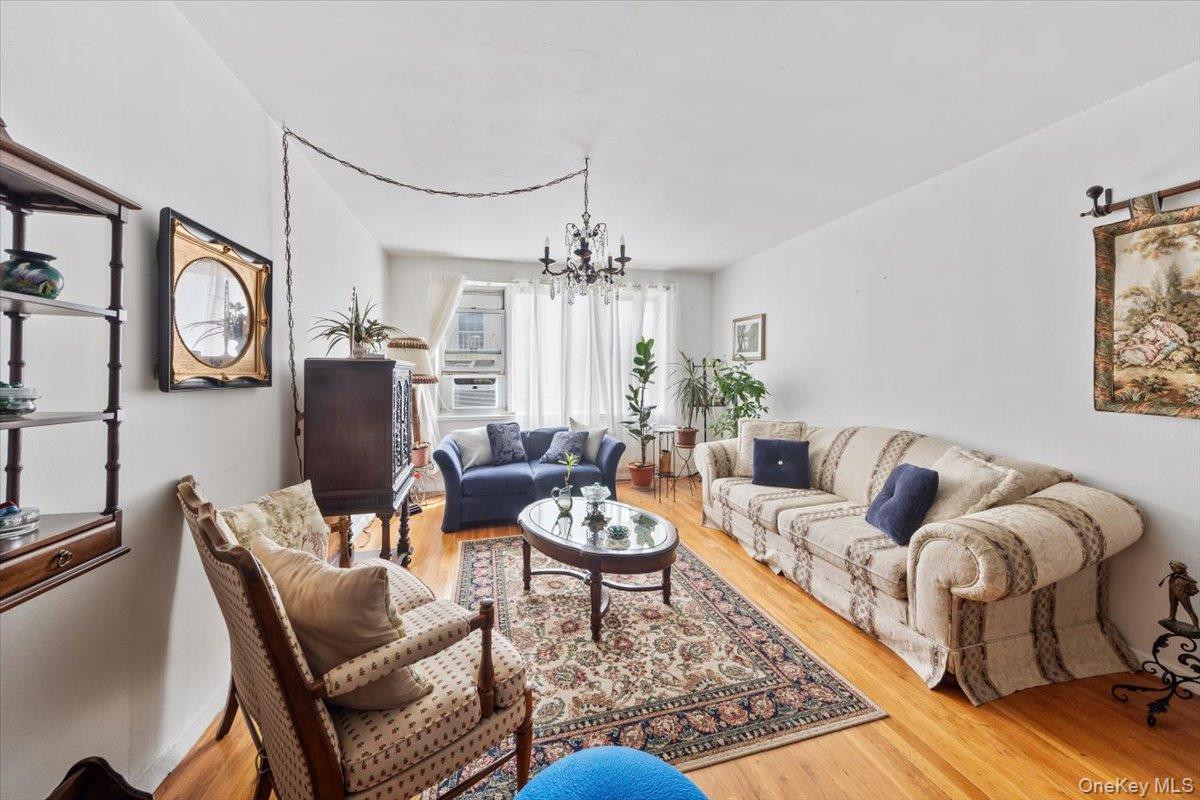 4265 Webster Avenue, Unit 7C Bronx, NY 10470 - Photo 9 of 22 a living room with furniture a chandelier and a rug