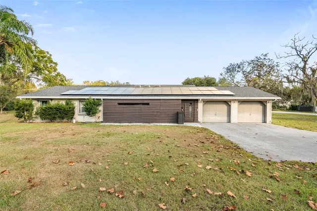 a front view of a house with a yard and potted plants