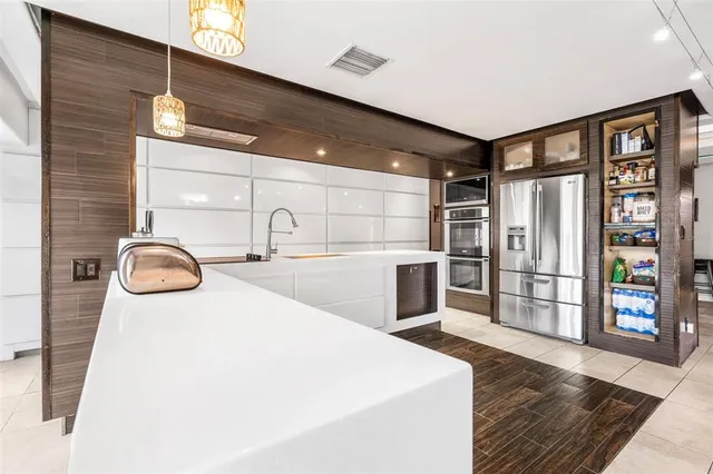 a room with kitchen island granite countertop a stove and a sink
