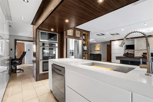 a kitchen with a refrigerator and white cabinets
