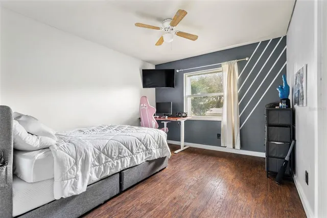 a bedroom with a bed and wooden floor