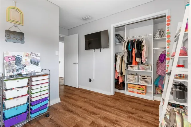 a bed sitting in a spacious bedroom next to a window