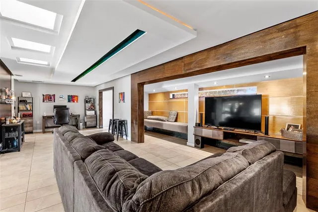 a room with stainless steel appliances kitchen island granite countertop a refrigerator and a sink