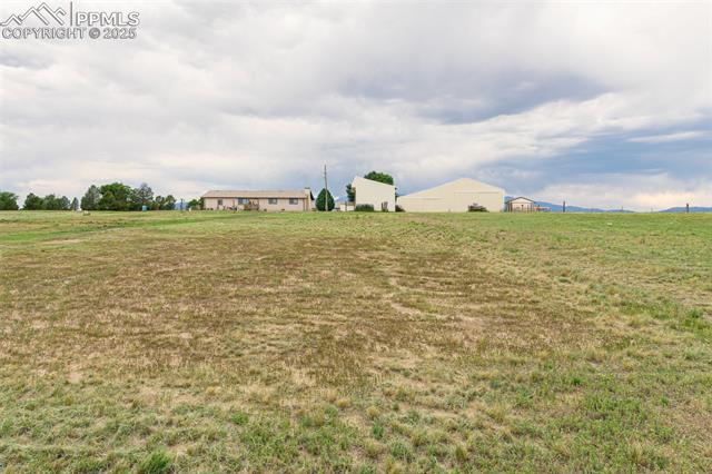 11170 Peaceful Valley Road Colorado Springs, CO 80925 - Photo 39 of 49 View of grassy yard featuring a view of rural / pastoral area