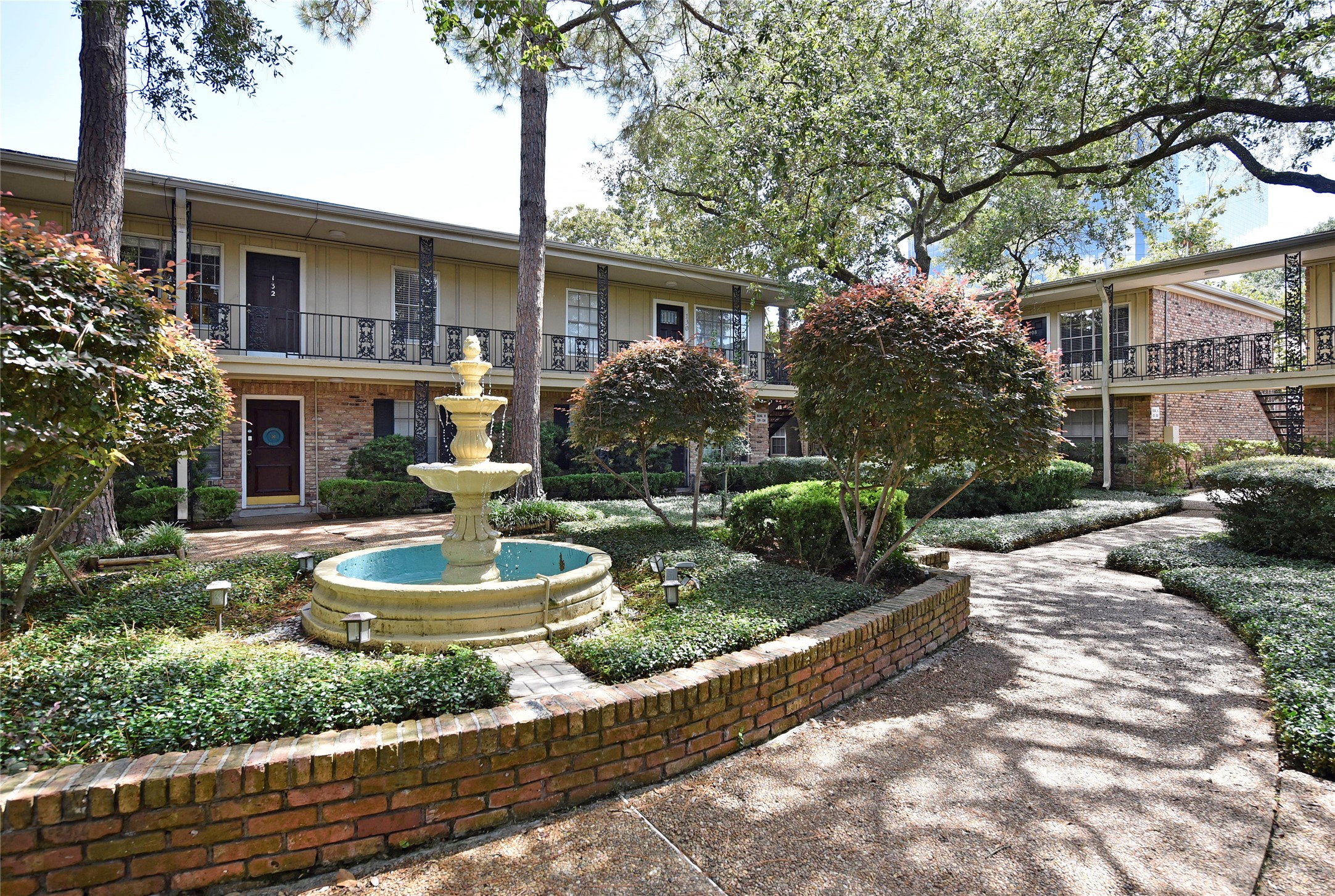 3224 Timmons Lane, Unit 112 Houston, TX 77027 - Photo 4 of 30 a front view of a house with garden and porch