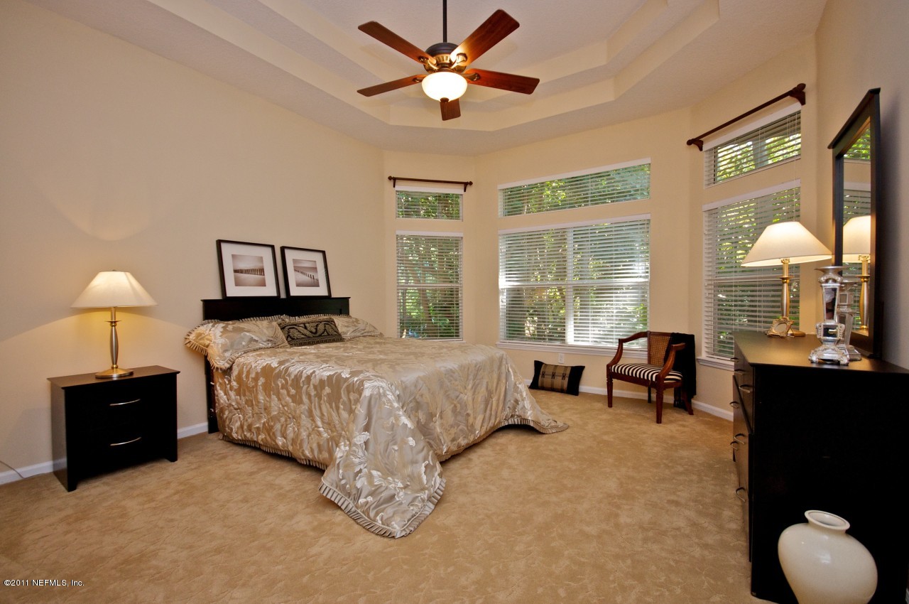 860 Mill Stream Road Ponte Vedra, FL 32082 - Photo 27 of 28 a spacious bedroom with a bed and a chandelier