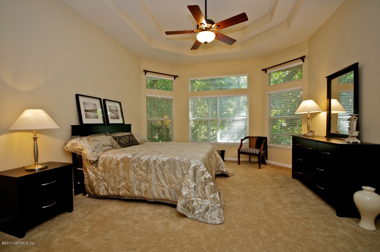 860 Mill Stream Road Ponte Vedra, FL 32082 - Photo 8 of 28 a bedroom with a bed and a chandelier fan