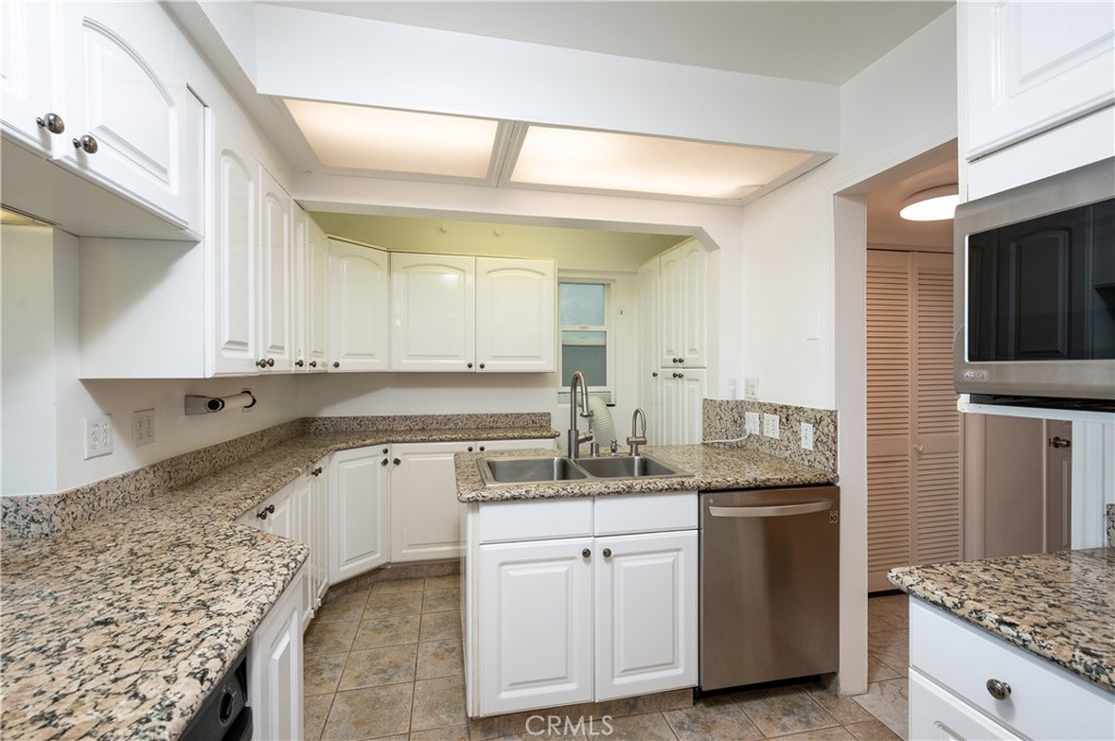 532 The Strand Hermosa Beach, CA 90254 - Photo 3 of 11 a kitchen with granite countertop a sink stainless steel appliances and white cabinets