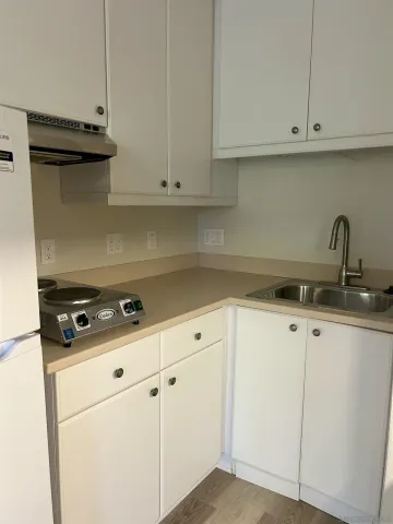 a kitchen with white cabinets and white appliances