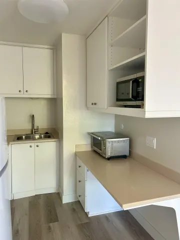 a view of a room with wooden floor and a bathroom
