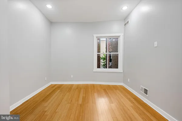 a view of a room with wooden floor and small window