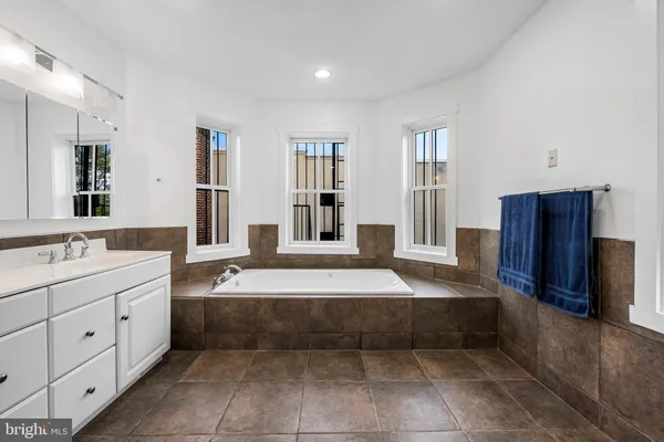 a spacious en suite bathroom with a tub sink and mirror