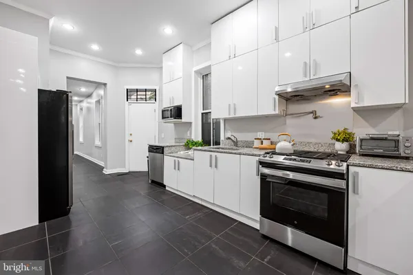 a kitchen with stainless steel appliances granite countertop a refrigerator and a stove top oven