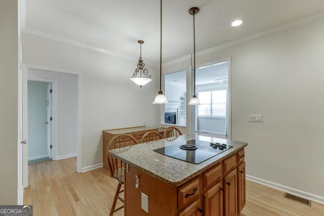 a kitchen with a sink a chandelier and wooden floor